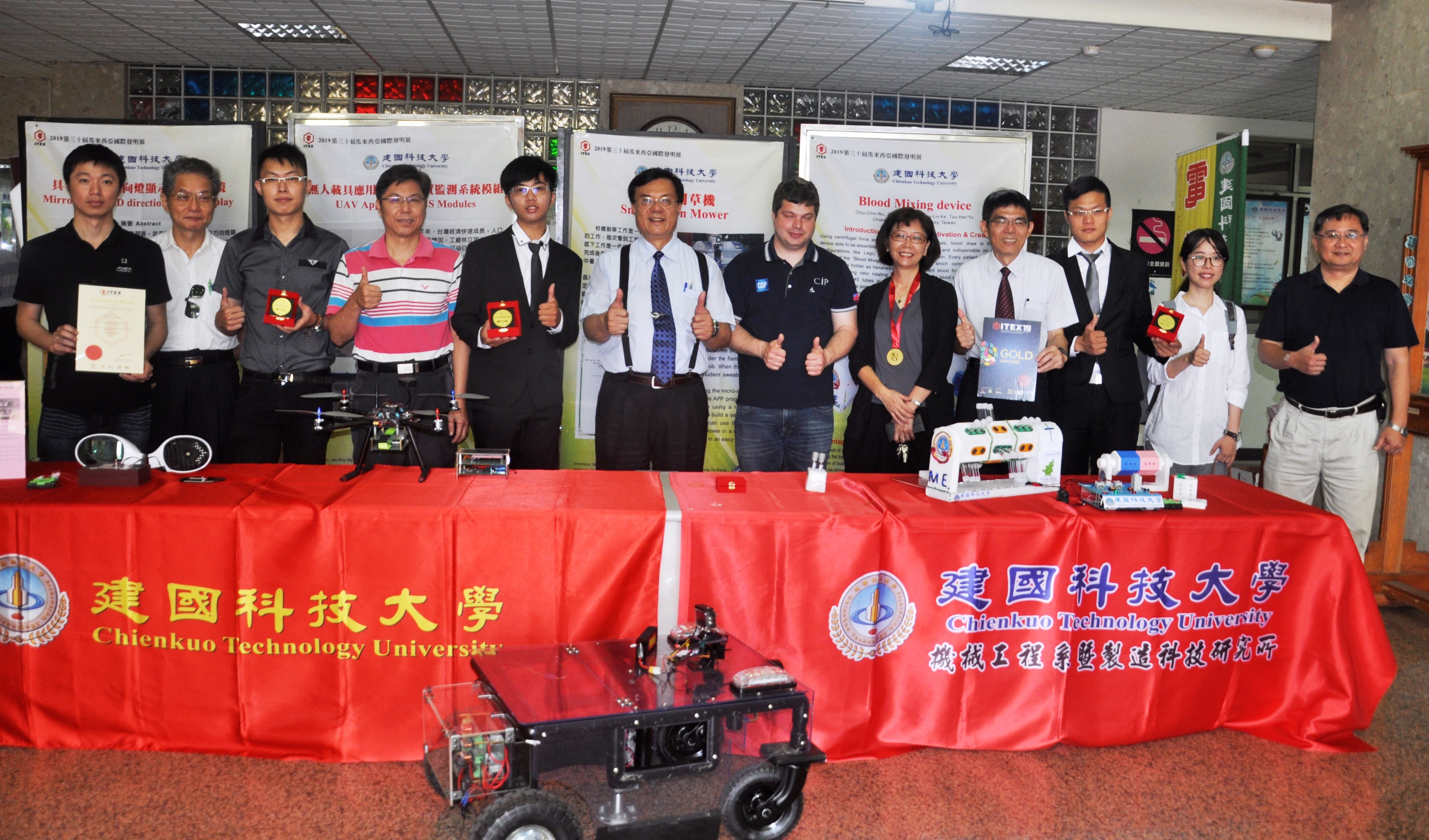 馬來西亞ITEX國際發明展，建國科技大學以「血液混合裝置」與「無人載具應用於空氣品質監測系統模組」、「具有LED方向燈顯示器之後照鏡」及「智慧型割草機」等4件作品參賽榮獲金牌，建國科大校長江金山(右七)與參加發明展獲獎師生合照