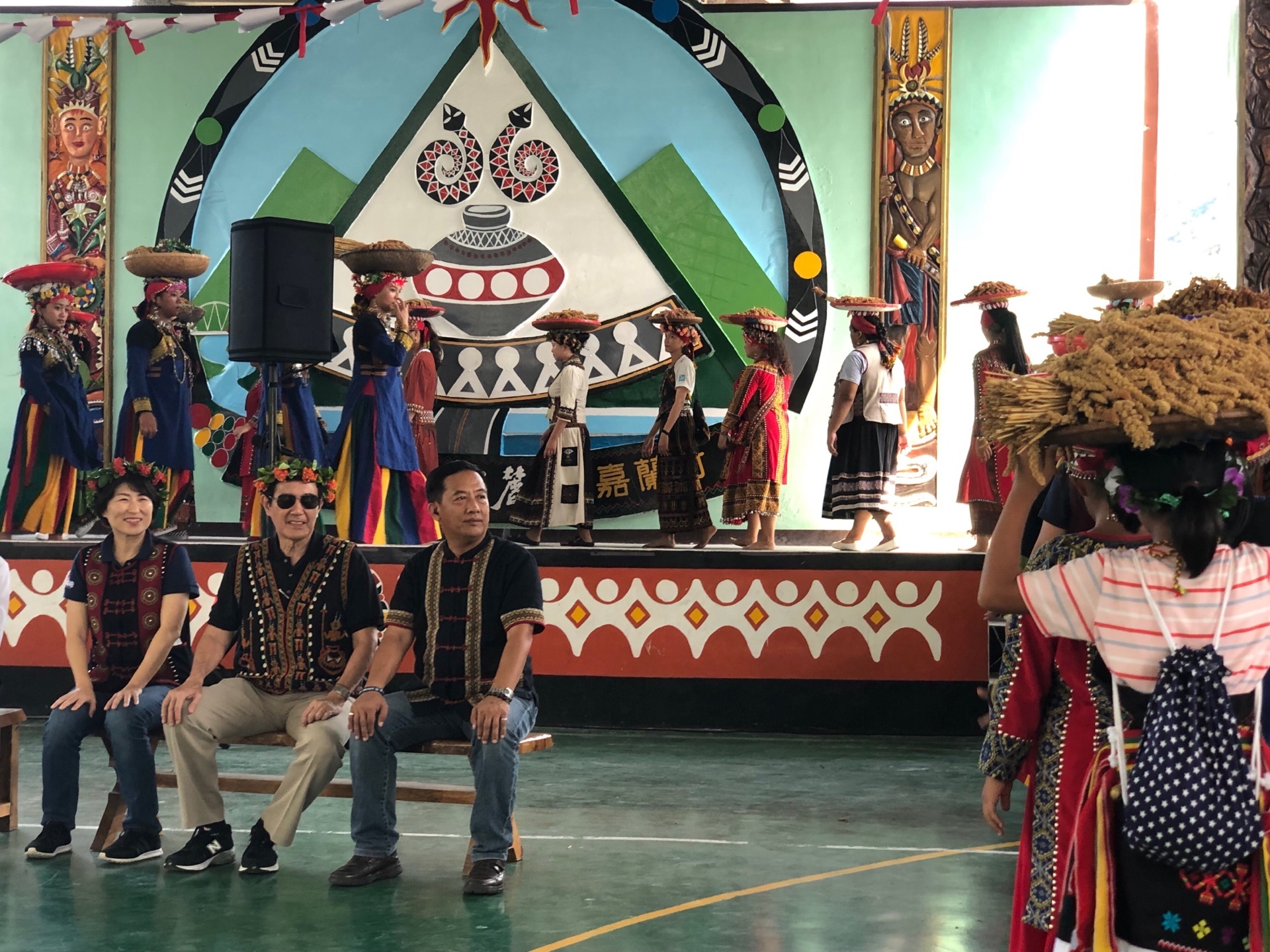 嘉蘭部落族人老中青三代，以「百人頂小米」方式，象徵族人堅定情感，馬前總統和饒縣長在場專心觀賞。