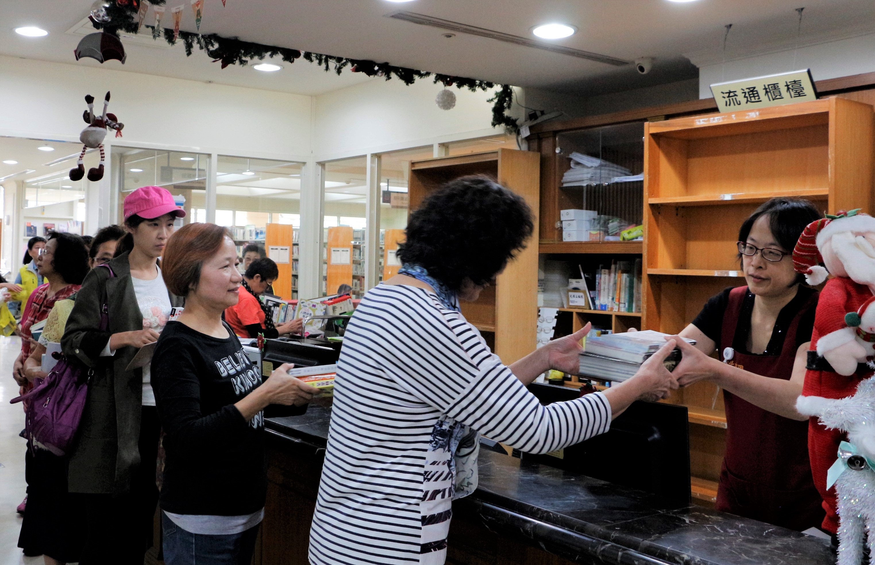 借書櫃檯前民眾則大排長龍，趕著閉館前的最後一刻，把書借回家