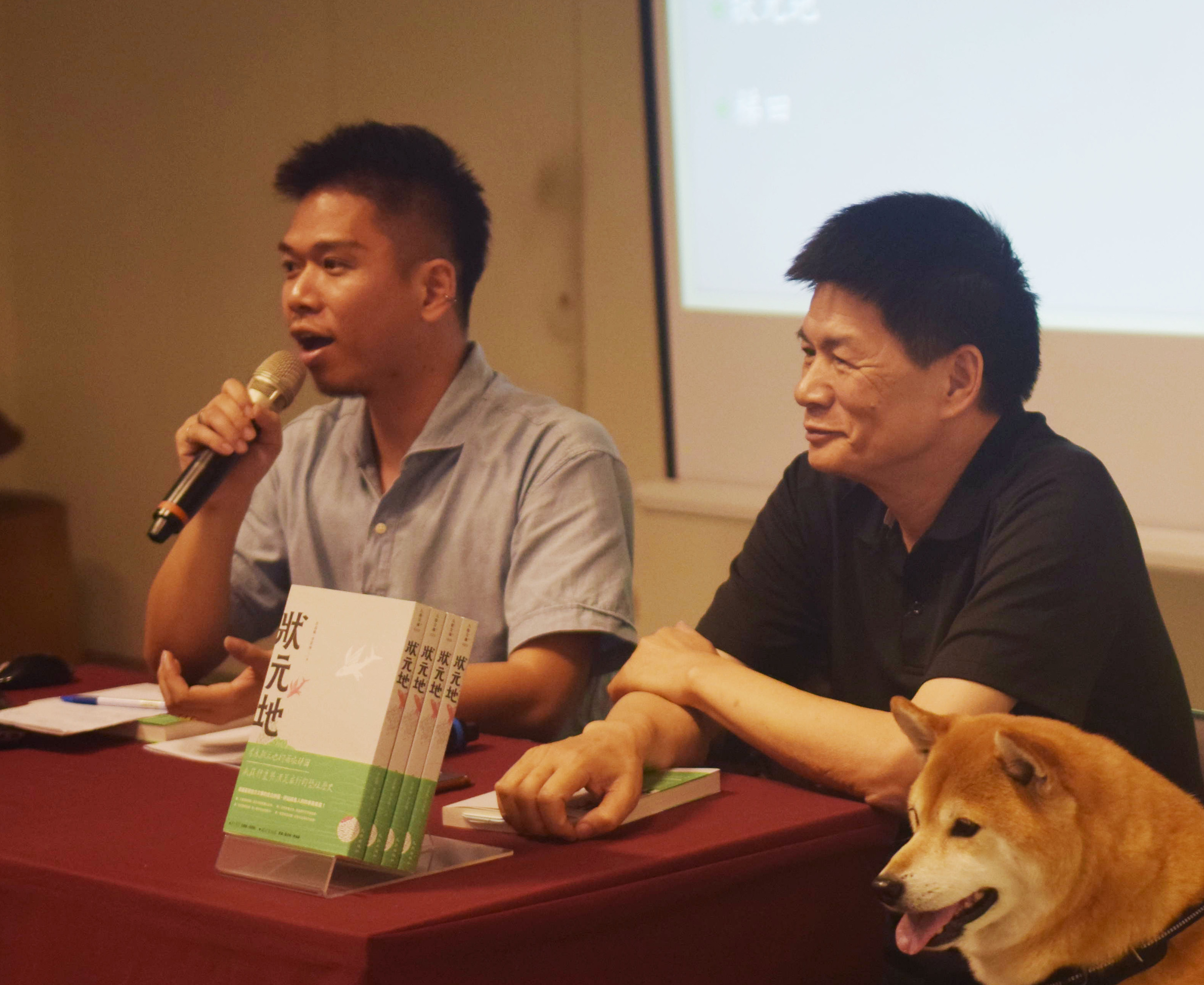 李校長(右)聽著兒子李家棟談到出版《狀元地》和父親的互動，臉上滿是笑容。