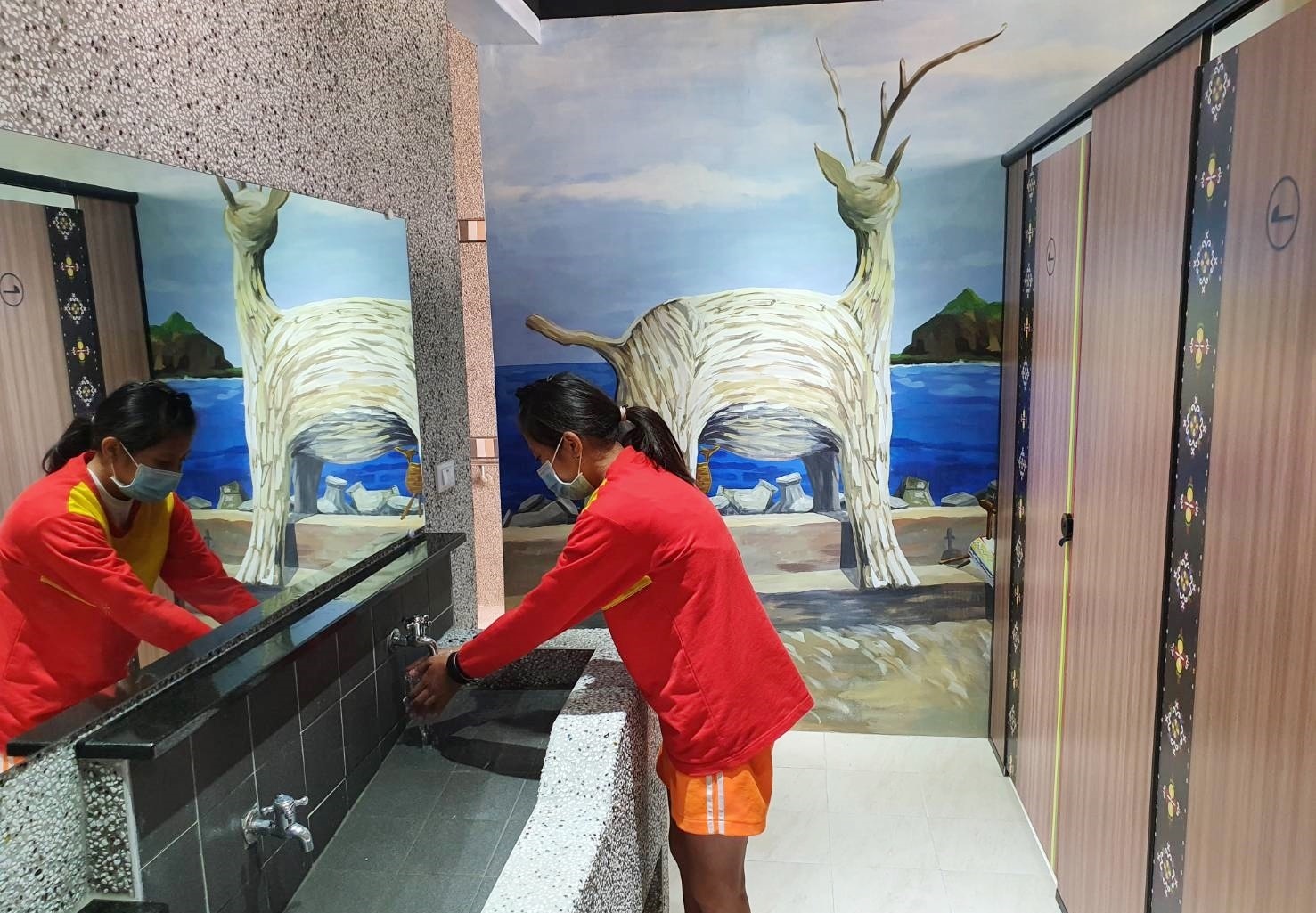 三仙國小新廁所設計中串聯阿美族圖騰與色彩，並將三仙臺日出、比西里岸著名的漂流木羊地景彩繪上牆面，走進廁所就能感受東海岸人文景致。