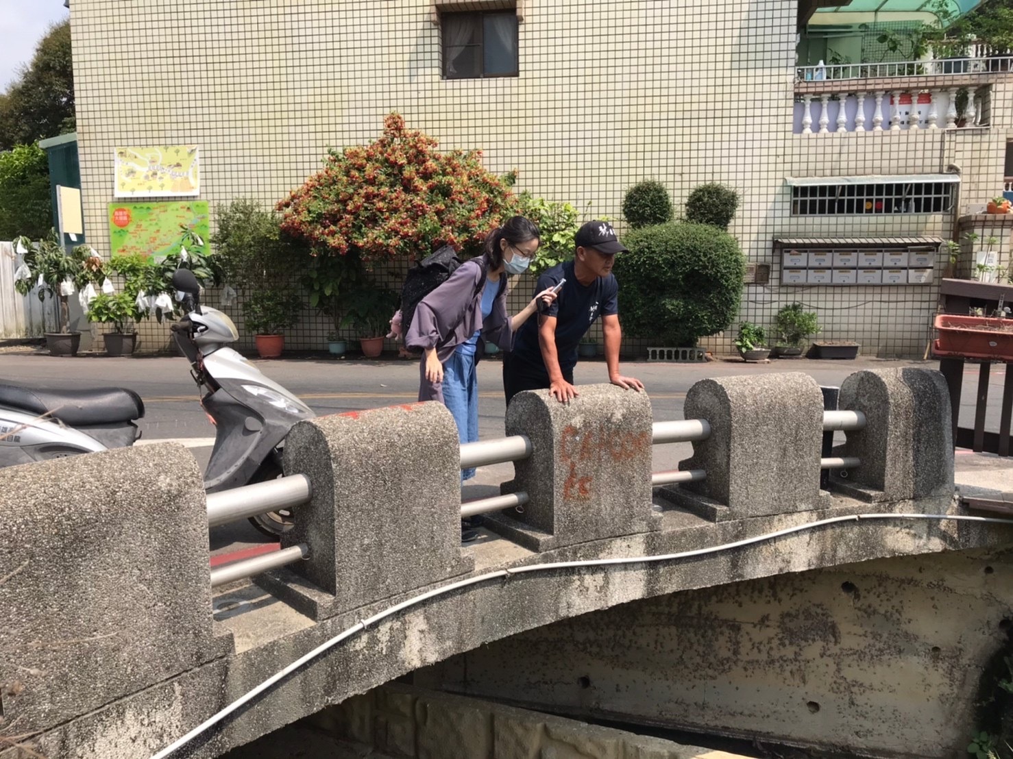 龍目里里長陳榮清(右)站在龍目排水溝上分享排水溝雨水、汙水分流設計。