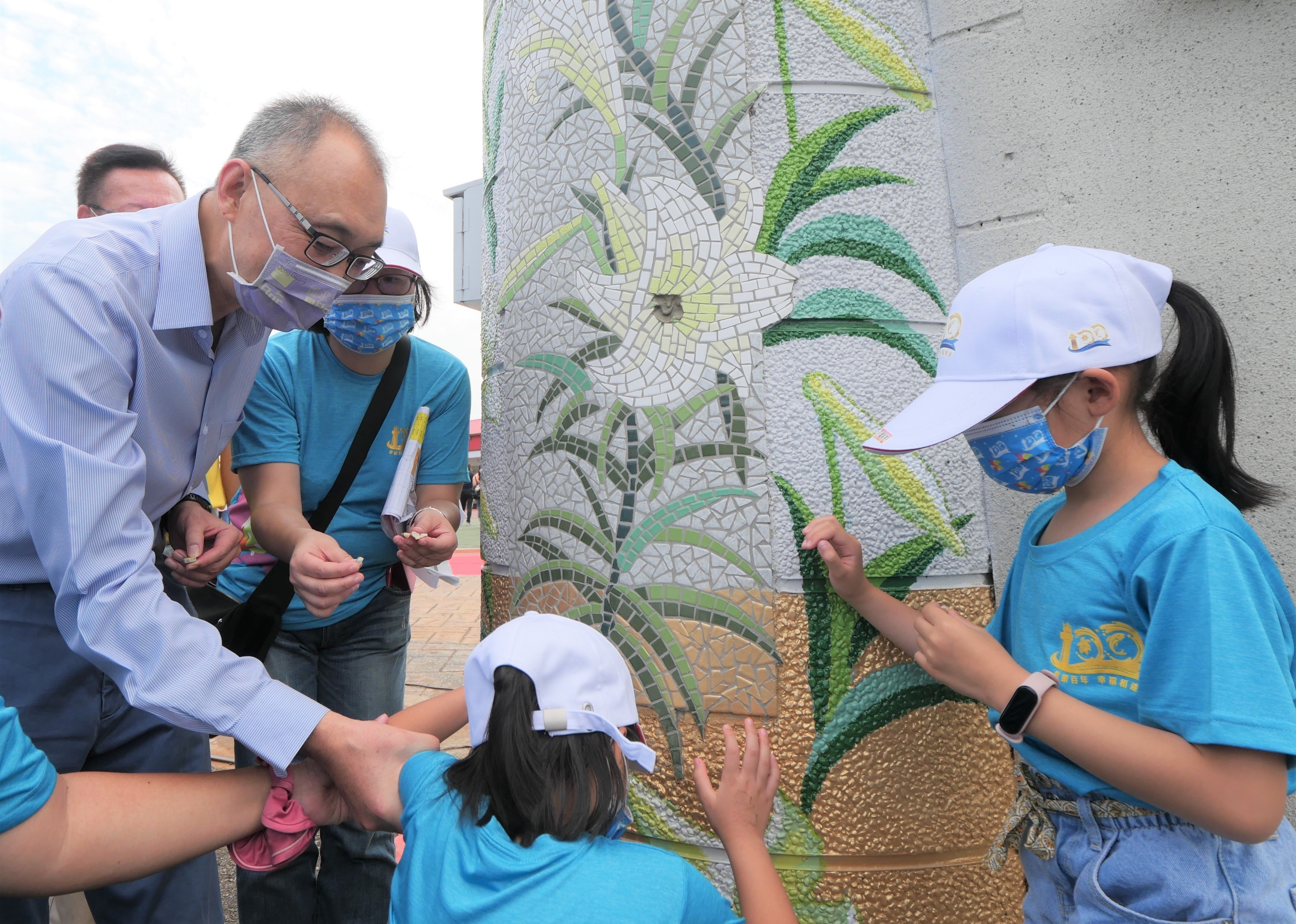 副市長謝政達與學生共同拼貼完成校門最後一塊百合花馬賽克圖案，作為100週年校慶紀念。