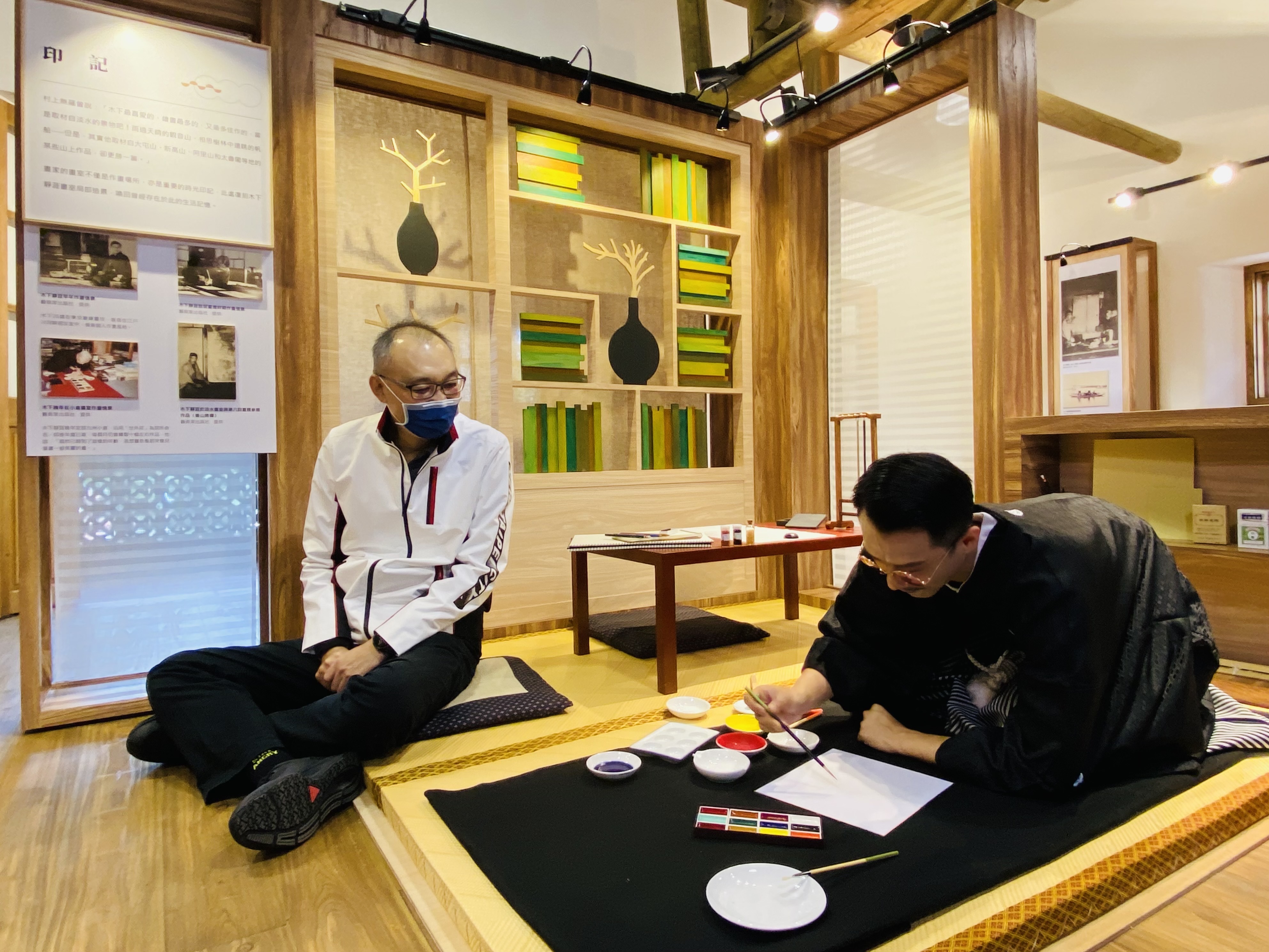 新北市副市長謝政達（左）在復刻的畫室欣賞飾演木下靜涯的演員作畫。