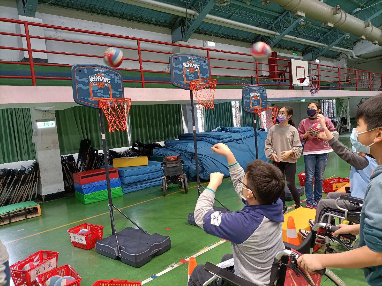 「輪椅投籃」則讓學童體驗自行或他人協助推動輪椅後，投擲籃球；