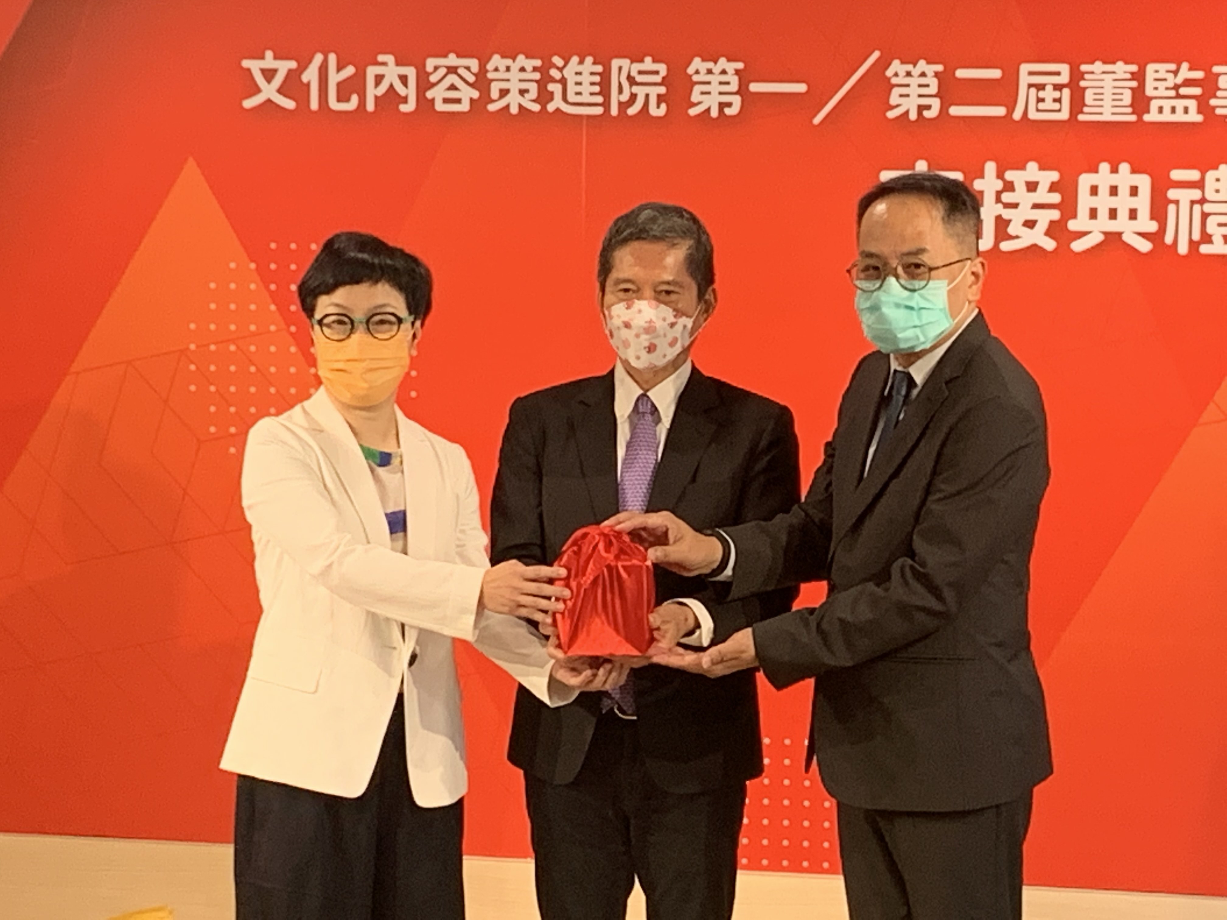 文策院新任董事長彭俊亨(右)與第一屆董事長丁曉菁(左)進行交接，並由文化部長李永得(中)擔任監交人