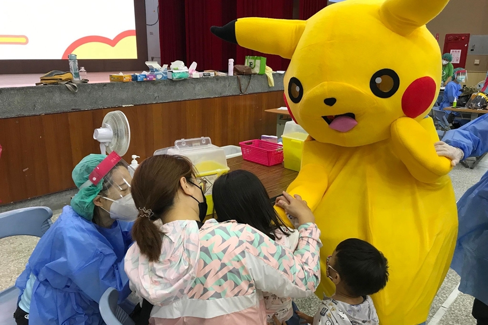 學童握著皮卡丘的手接種疫苗