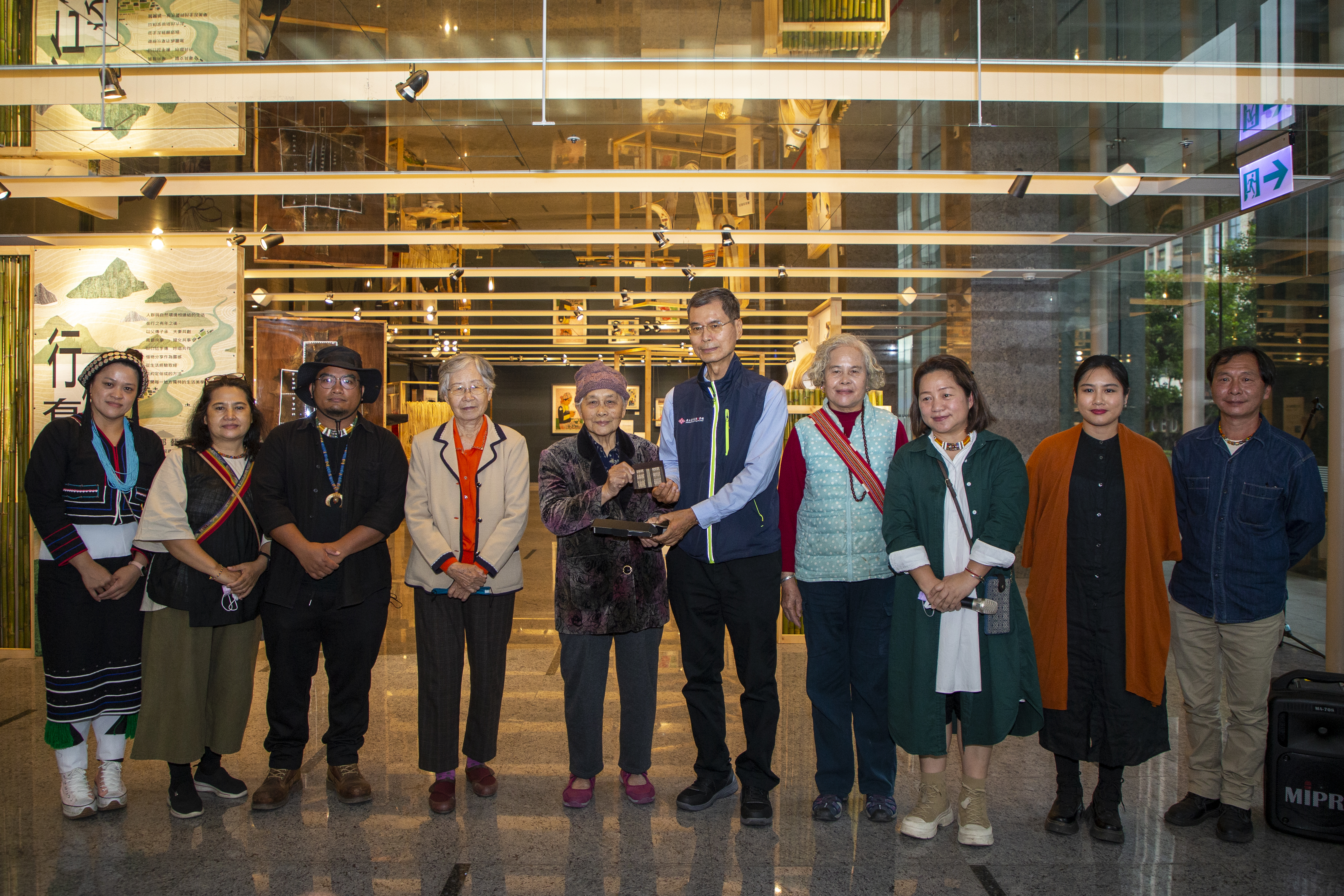 （左起）女仕女事工坊李玟慧、賢美工坊林賢華、拉日革安工坊林嘉倫、生活布藝創作藝術家張蘭芳、噶瑪蘭族香蕉絲織布人間國寶嚴玉英、國立臺東生活美學館長江愚、太巴塱傳統阿美陶文化傳承者李玉英、策展人林秀慧、獨樹依織樹皮創作工作室林戎依、森川自然工藝聚落洪啟榮合影 (文化部提供)