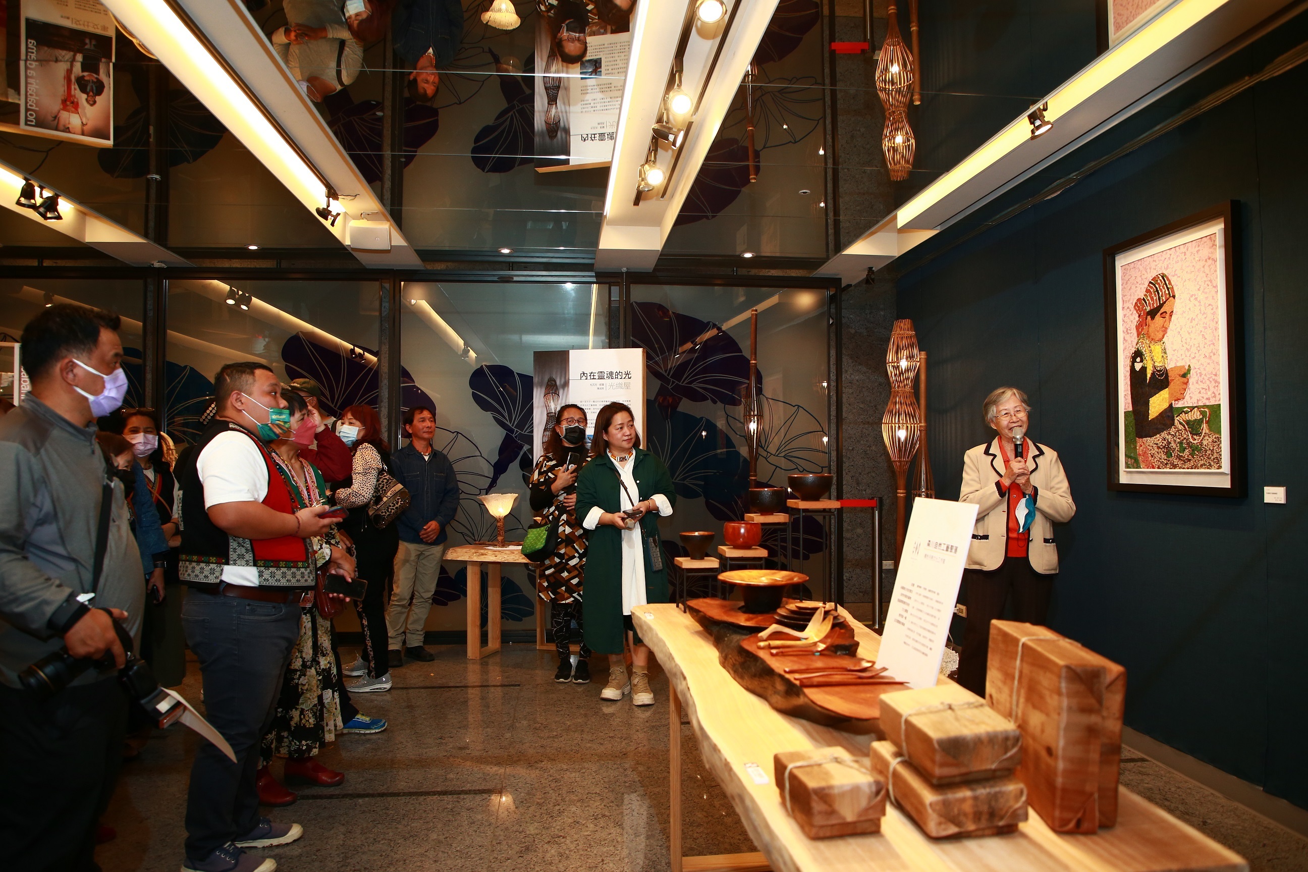 臺東生活布藝創作藝術家張蘭芳（右）向參展貴賓介紹作品〈布農婦女捲檳榔葉〉 (文化部提供)