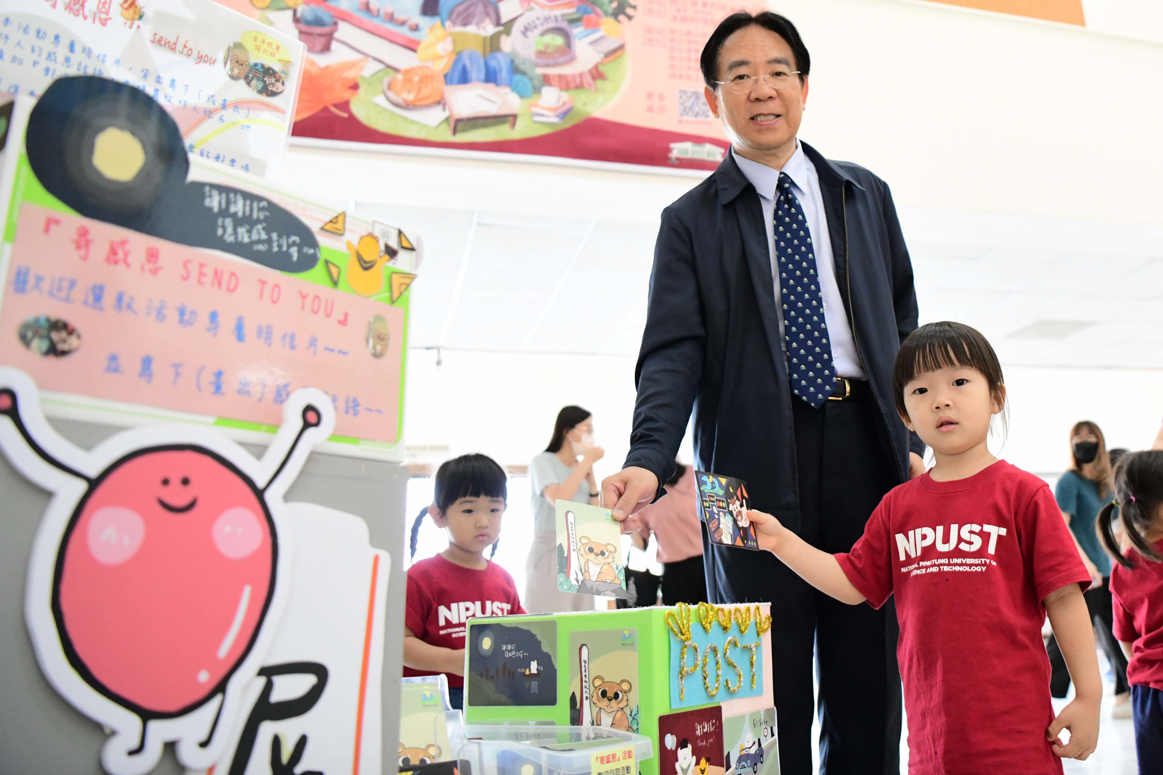 張金龍校長(左)與小朋友一起投遞感恩明信片(右)