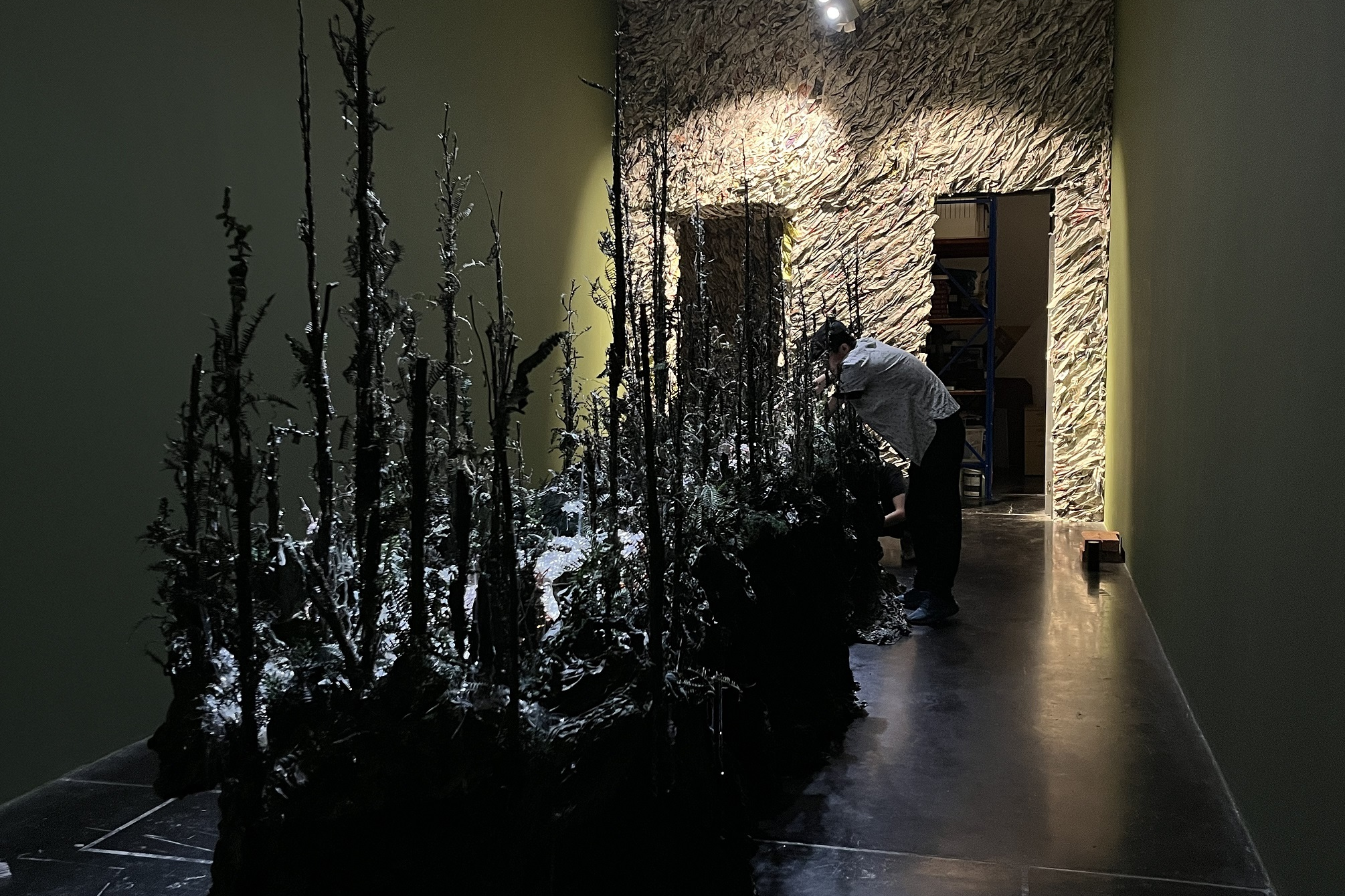 《複眼叢林》將於本週末在馬來西亞伊爾罕美術館登場，張徐展於展場調整作品細節。(文化部提供)