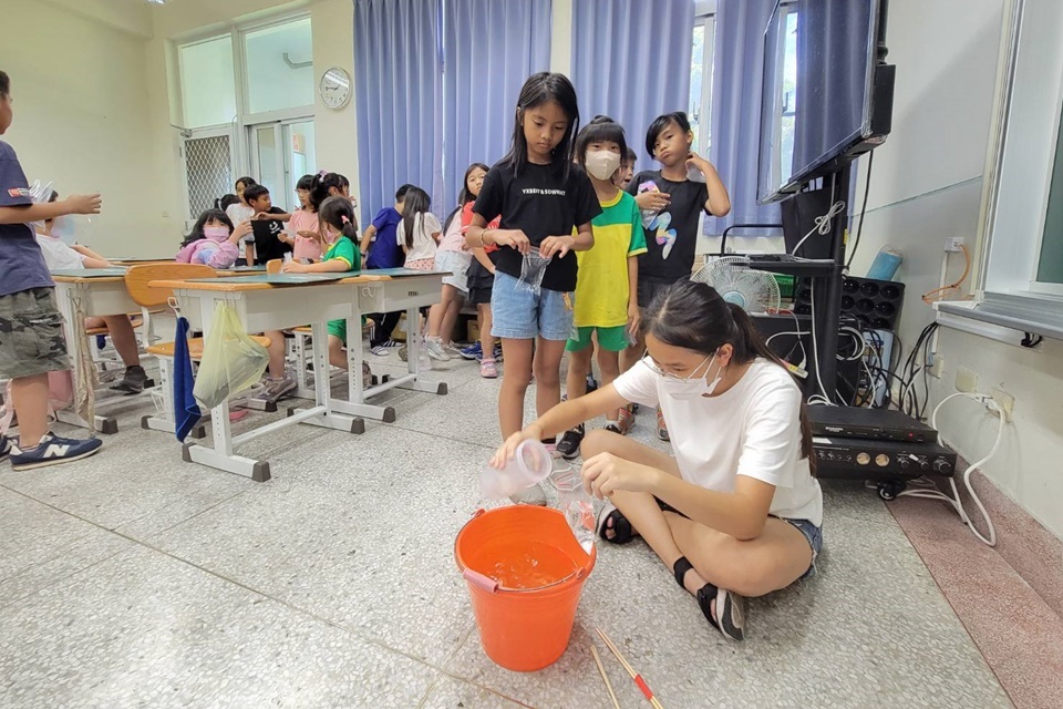 學生們排隊領取調配好的檸檬酸水溶液，為製作爆炸包做準備。