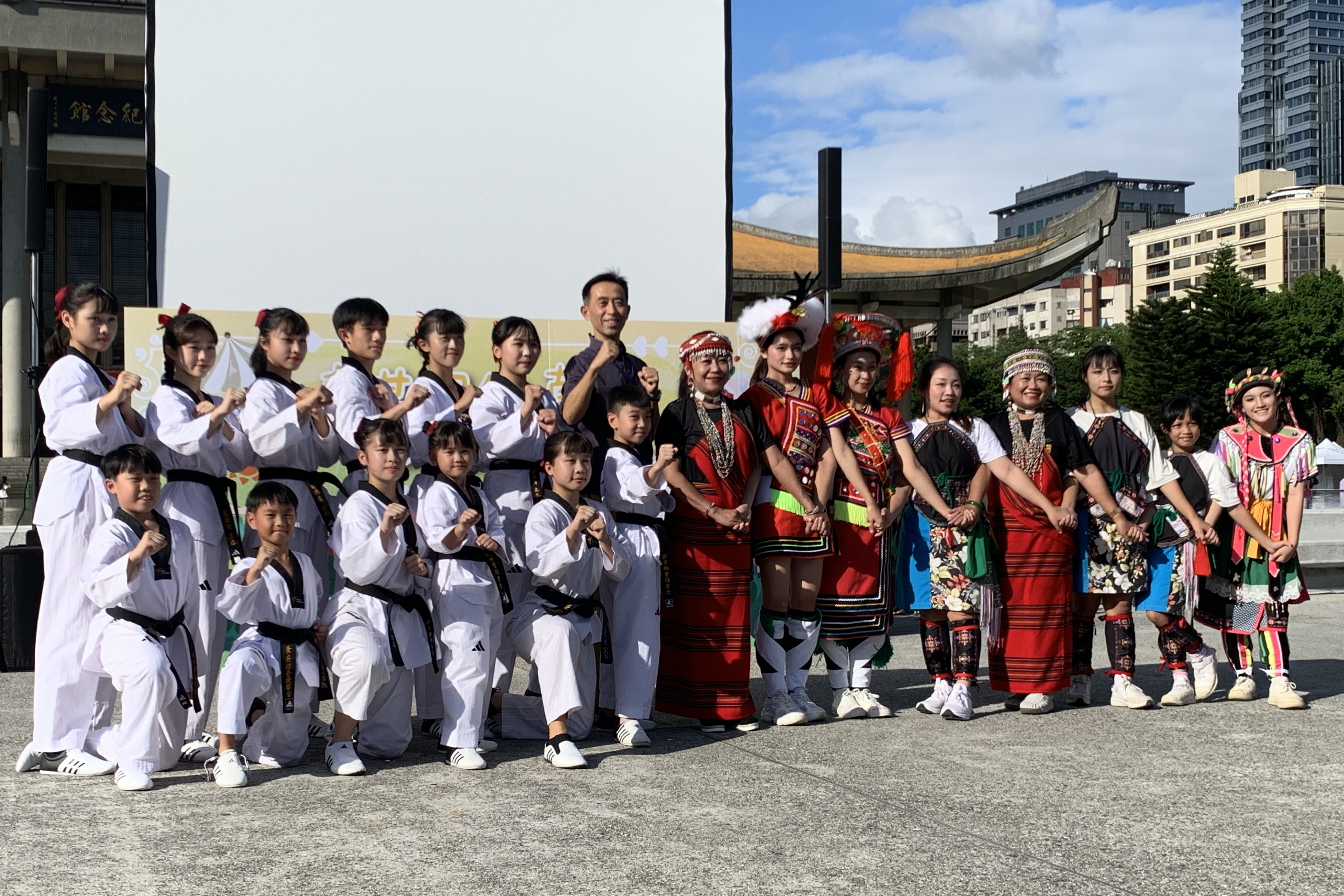 國父紀念館王蘭生館長(中後)與國立體育大學的跆拳道女性運動員，以及頭角原住民文化藝術團合影