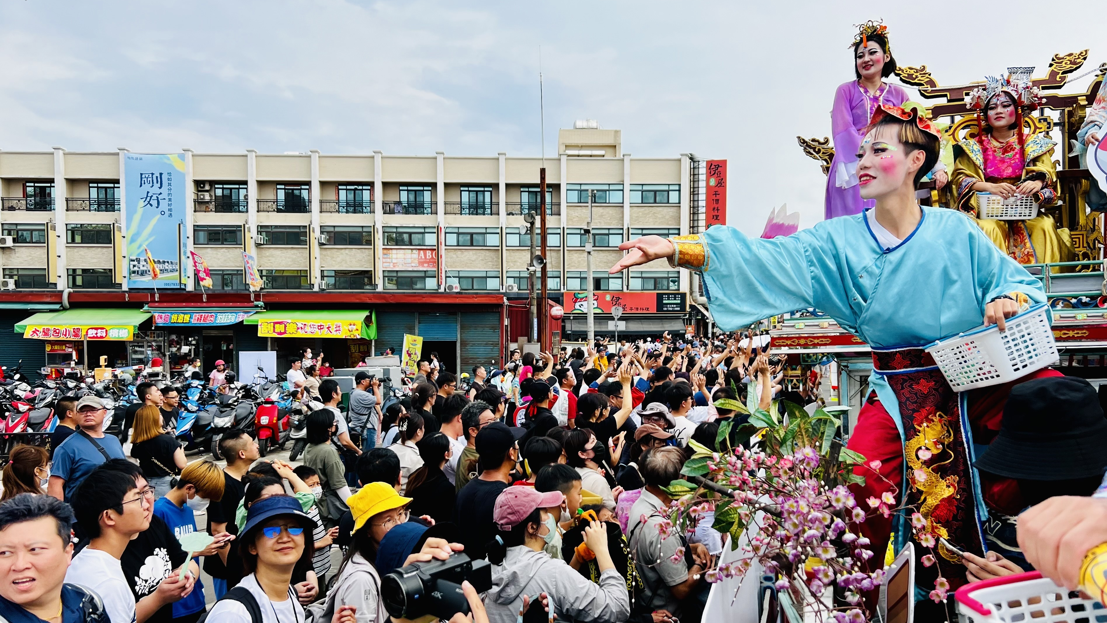 媽祖遶境，「扮藝閣」的學生在藝閣車上分送糖果與祝福