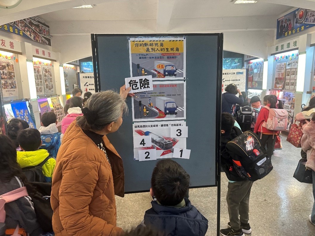 玉成國小規劃交通安全闖關活動，學生指出在大客車的背景圖畫中的危險區域，以及內輪差位置