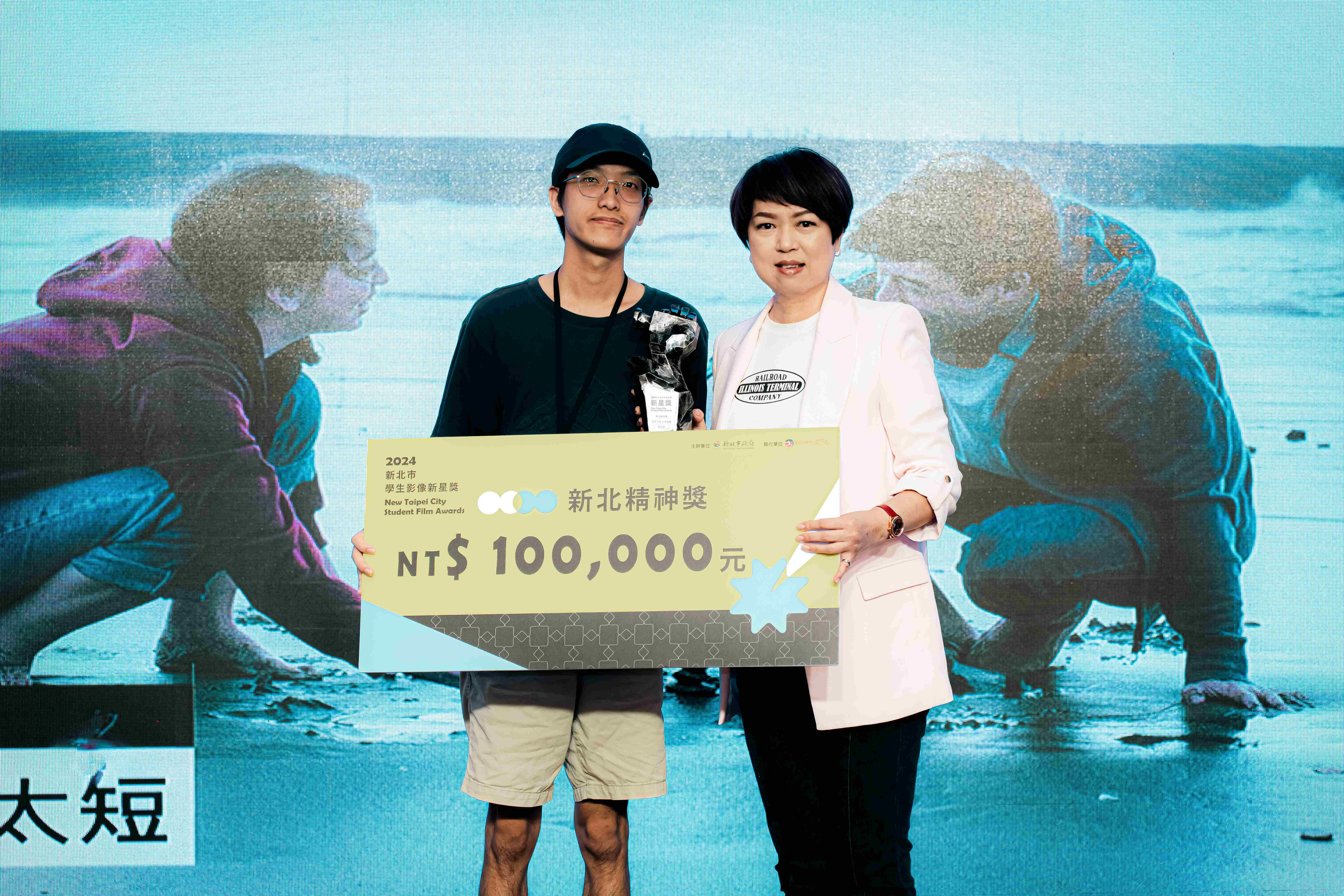 龔雅雯副秘書長(右)頒發2024新北市學生影像新星獎【新北精神獎】得獎作品《明天太遠 今天太短》獎項(由副導李念聰代領)