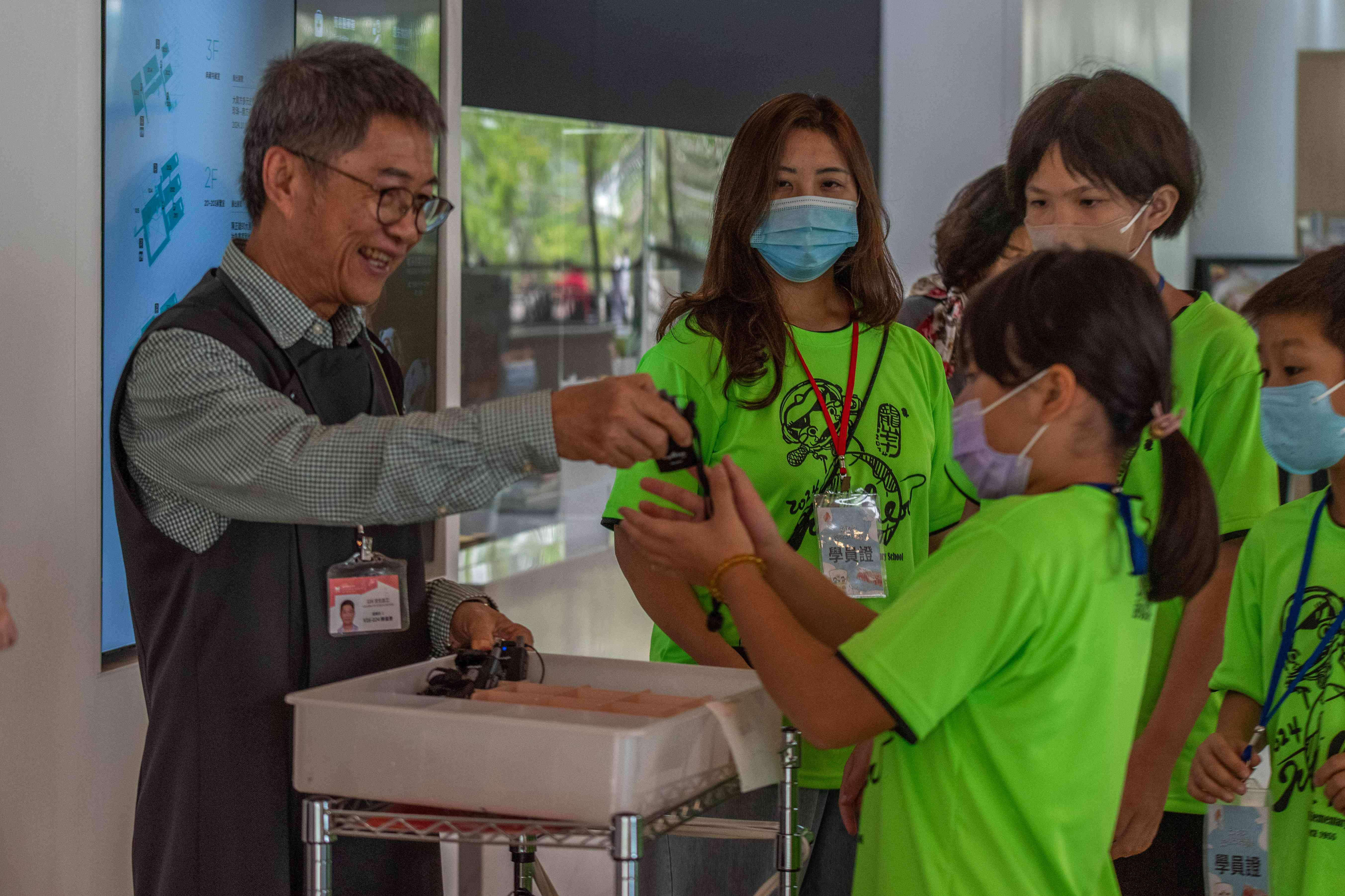 高美館展場志工協助團體配戴導覽子機。（高美館提供）