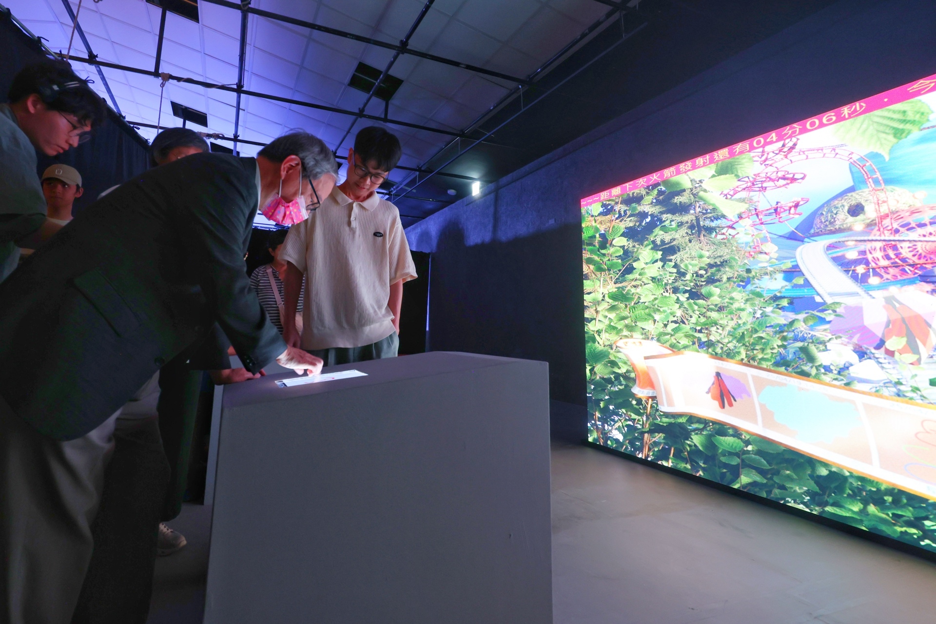 文化部長李遠（左）參觀「互動書展—GoGo 冒險去！」展區，現場體驗互動科技所帶來的沉浸式閱讀體驗 (文化部提供)