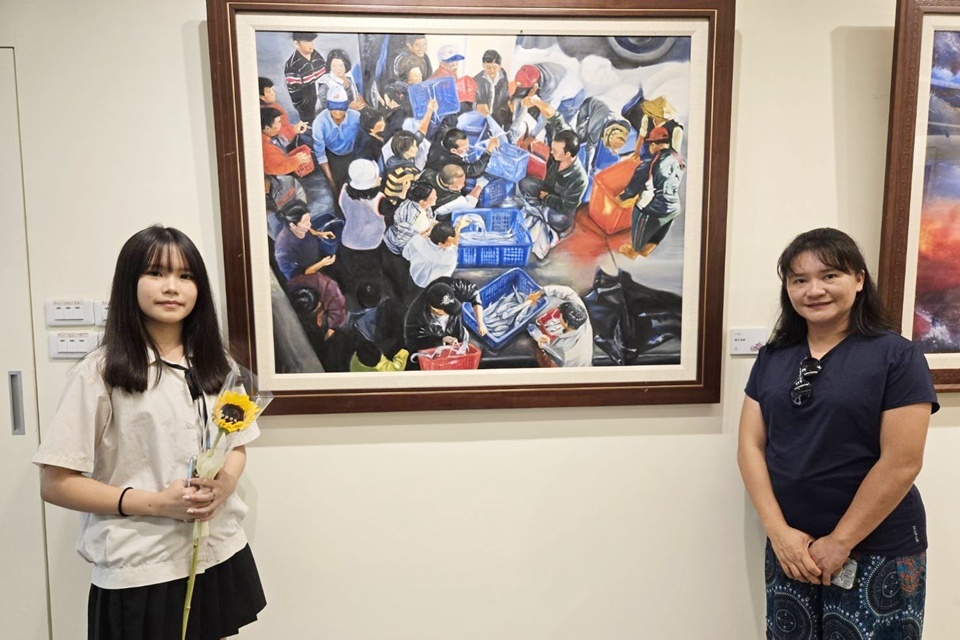 國立臺東女中學生王家渝(左)作品《晨光漁影》描繪家鄉搶魚文化，也刻畫兒時與父母的甜蜜回憶，與母親潘采璿(右)合影。