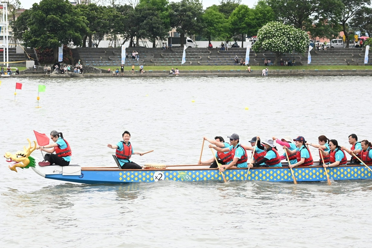 與岸邊熱情加油團致意的賴同學 (教育部提供)