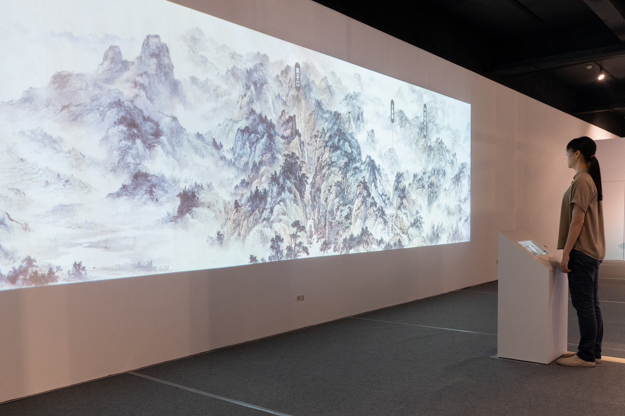 「歷史神展開－松山奉天宮X國立歷史博物館」特展以數位互動展示典藏書畫，觀眾可觸控觀看＜寶島長春圖卷＞作品細節。(史博館提供)