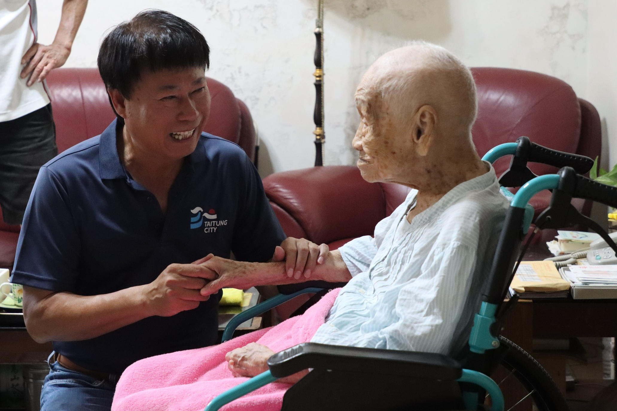 臺東市長陳銘風送重陽節禮物給住在市區最年長106歲的人瑞蔡耐冬女士，兩人並且握手話家常。