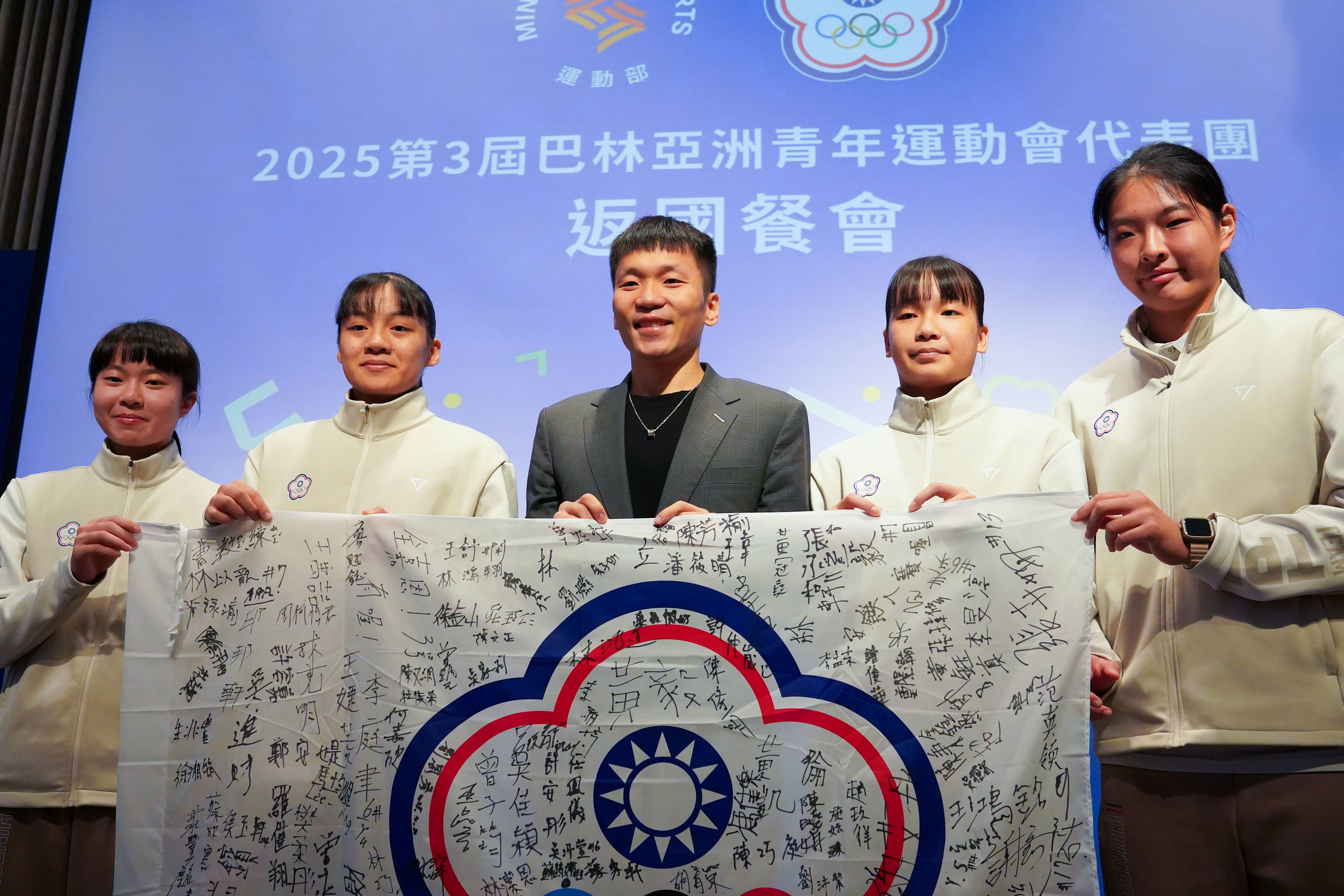 女籃3X3選手代表（左起吳沛萱、陳芯、謝艾彤、喬麗爾）致贈李洋部長簽名會旗。(運動部提供)