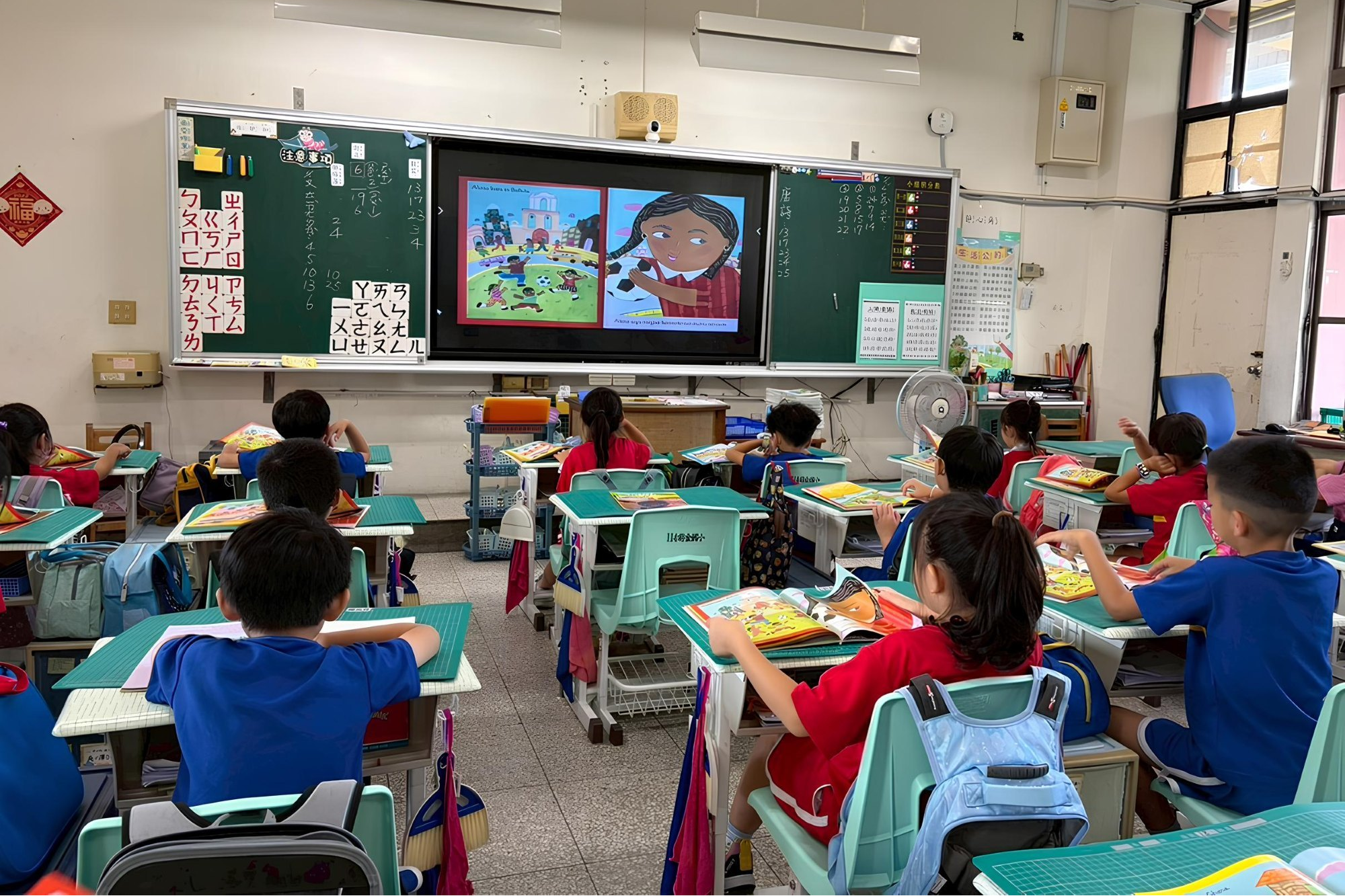 高雄市前金國小學童以紙本繪本搭配電子有聲書進行閱讀，透過聲音與圖像的結合提升理解與專注度(教育部提供)